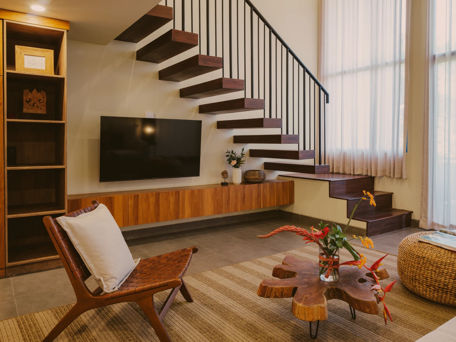 Mezzanine apartment lounge with open-tread staircase and media console